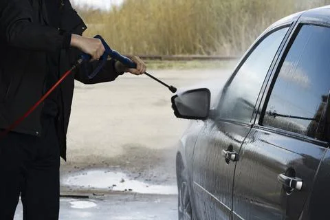 A man washes the side mirrors Stock Photos