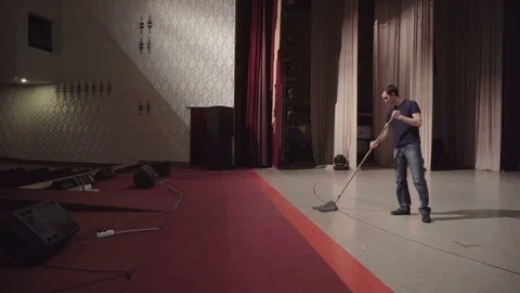 Man washes theater stage using a mop Stock Footage 71767267