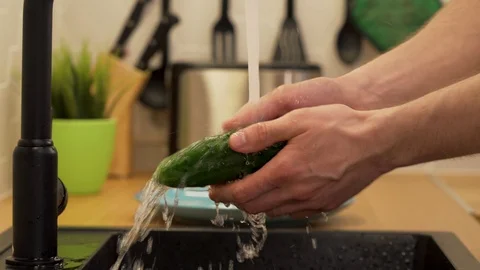 A man washes under running water cucumbers Stock Footage 129054115