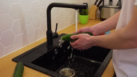 A man washes under running water cucumbers Vídeo Stock 129054116