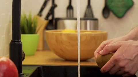 A man washes under running water kiwi Stock Footage 129054454