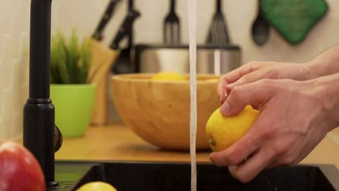 A man washes under running water lemons Stock Footage 129054460