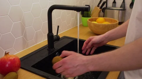 A man washes under running water kiwi Stock Footage 129054498