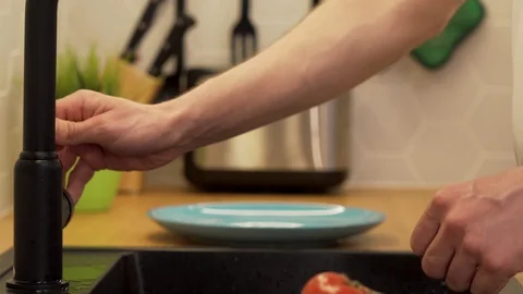 A man washes under running water the tomatoes Stock Footage 129054507