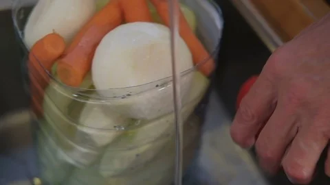 Man washes vegetables in a plastic bottle. Male hands cook food Stock Footage 102132269