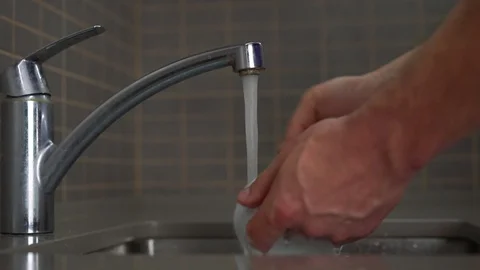 Man washes white cup and plate under water cleaning kitchen Stock Footage 119982260