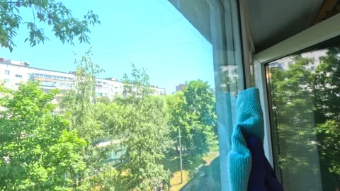 A man washes a window in an apartment building Stock Footage 278403491