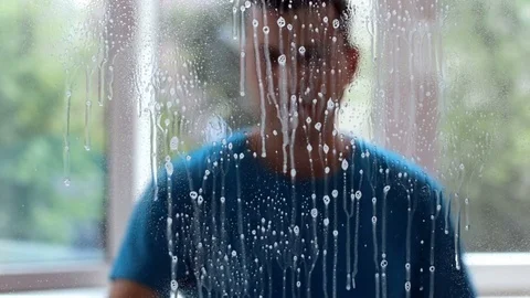 A man washes windows at home Stock Footage 82338404