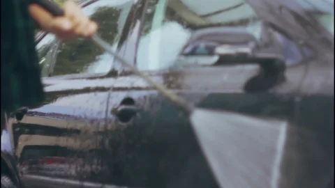 A man washing a car using a stream of water Video stock 117112677