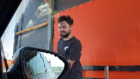 Man is washing car. View from inside the automobile. Close-up. Man is washing Stock Footage 245551769
