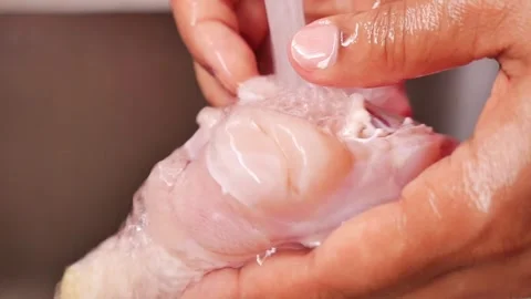 Man washing chicken under running water in kitchen sink Stock Footage 346799253