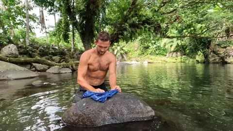 A man washing clothes in the river Stock Footage 278510248