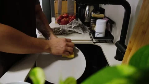 Man washing dishes with a sponge in the kitchen sink Stock Footage 345733464