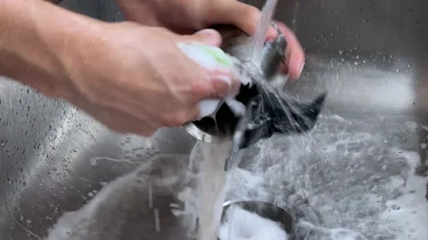 Man washing a geyser coffee maker. His hands close-up Stock Footage 233474183
