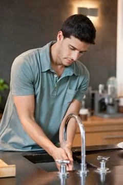 Man washing hands in the kitchen Stock Photos