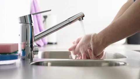 Man washing hands in kitchen sink with water from tap. Hygiene concept. Stock Footage 104587611