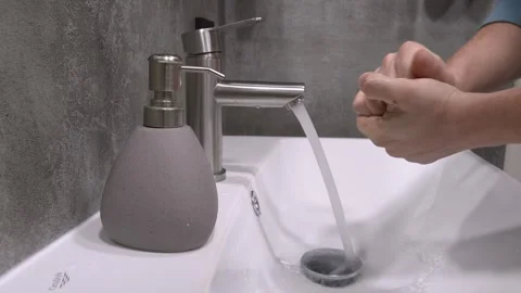 Man washing hands with soap and water in bathroom sink 库存影片 302540850