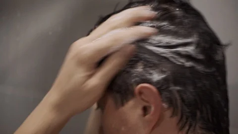 Man is washing head in shower Stock Footage 128321491