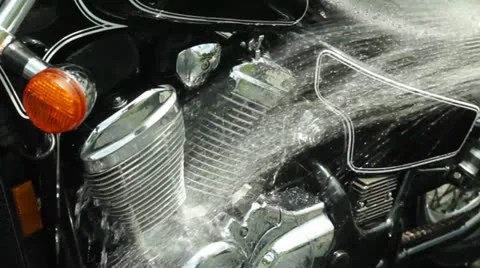 Man washing motorcycle cu of engine rinsing off Stock Footage 24635735