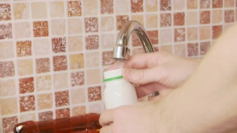Man washing plastic bottles in the sink Stock Footage 155486232