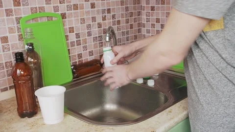 Man washing plastic bottles in the sink Stock Footage 155486256