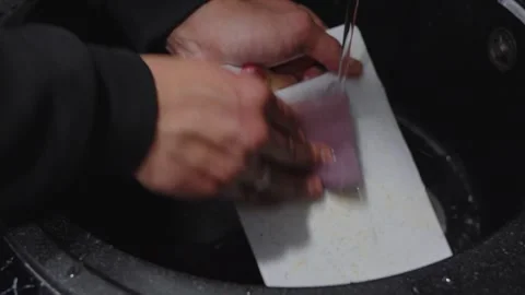 Man Washing Plastic Cutting Board with Sponge in Kitchen Sink Stockbeeldmateriaal 345100196