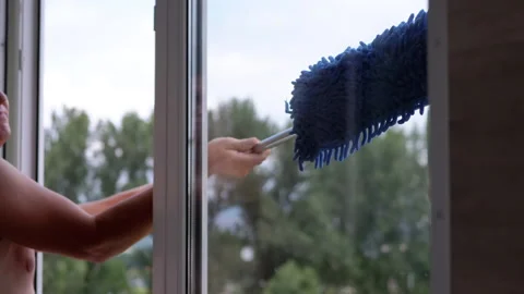 A Man Washing Windows on a Balcony with a Mop and Microfiber Cloth. Zoom Stock Footage 206358025