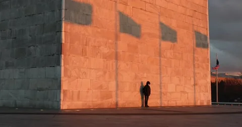 A man at the Washington Monument at sunset Stock Footage 148107379