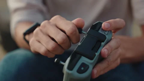 A man with watches connecting a controller stick to a drone controller, close up Stock Footage 252643124