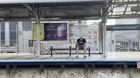 Man watches his phone at the elevated train station Stock Footage 278931658
