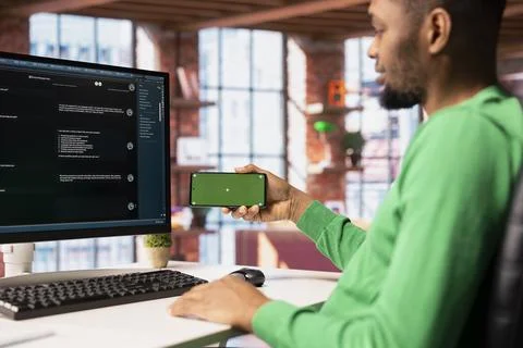 Man watches tutorial on mockup phone to learn how to solve tasks with AI chatbot Fotos de archivo