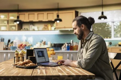 Man watching AI features on video streaming platform with laptop Fotos de archivo