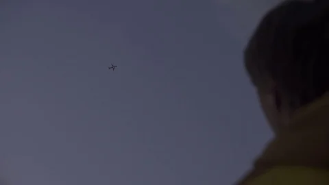 Man watching airplane fly through blue sky Stock-Footage 72503484