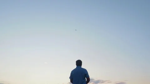 Man watching and navigate a flying drone in summer sunset, sky Stock Footage 114384319