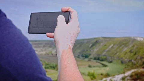 The man is watching the Bitcoin exchange on the phone. It is in a place on the Stock Footage 160700422