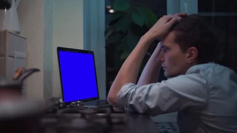 Man watching at blue key notebook computer display at kitchen near stove Stock Footage 83253582