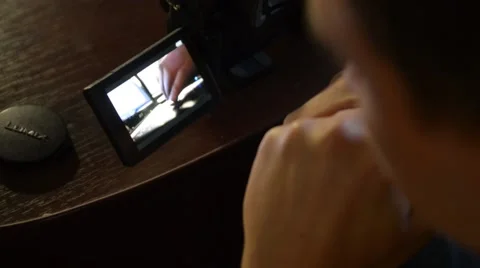 Man watching on camera screen recorded video Stock Footage 55849025