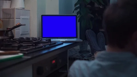 Man watching at chroma key notebook computer display at kitchen near stove Stock Footage 83253179