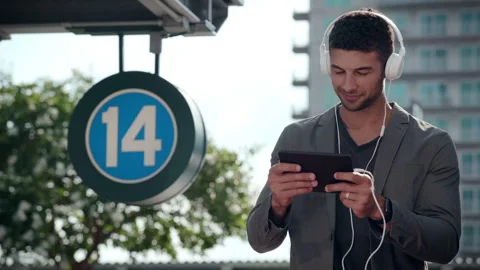 Man watching content on ipad in urban environment headphones on Stock Footage 298074613