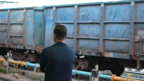 Man Watching Freight Train Wagons at Railway Yard Stock Footage 336884838