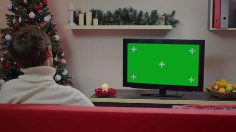 A man watching Green Screen Mockup TV in a Chrismas decorated living room. Stock Footage 314781907