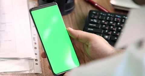 Man watching green screen smartphone display at office background Stock Footage 134075255