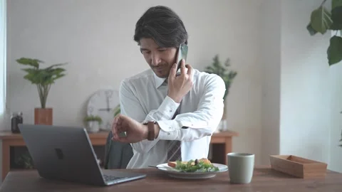 A Man Watching His Computer While Having Breakfast Stockbeeldmateriaal 332750327