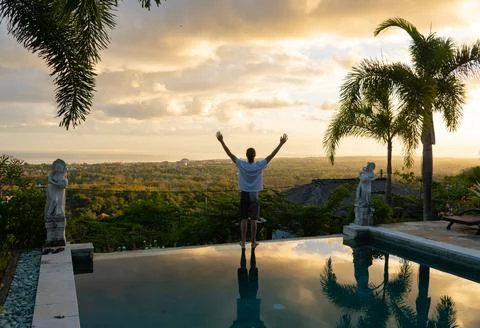 A man watching the horizon with his hands up Stock Photos