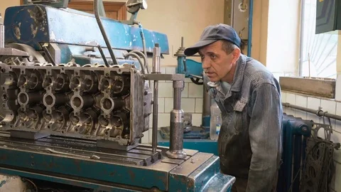 Man watching how cutter processes surface of cylinder head Stock Footage 81537809