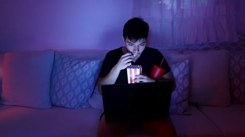 Man watching a movie on his computer Stock Footage 289992653