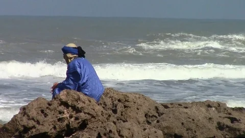 Man watching the ocean sitting on the rocks in Essaouira- Morocco Video stock 106559455