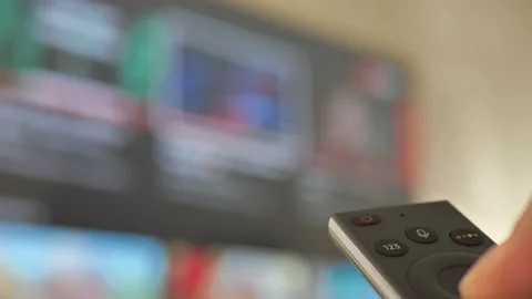 Man Watching Smart TV And Using Modern Black Remote Controller, Blurred TV In Stock Footage 170237817