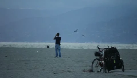 Man Watching Something On Beach Stock Footage 11360550