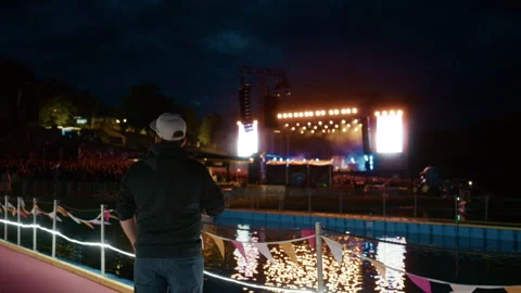 Man Watching Stage Performance at Night During Festival Stock Footage 345893113